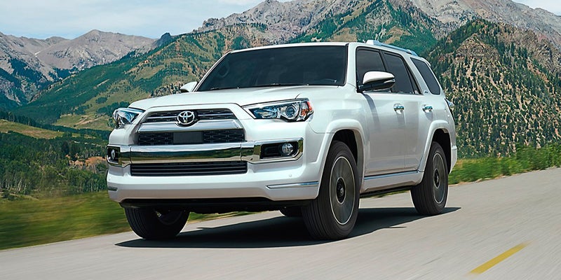 Image of a white Toyota Tacoma driving in a mountainous area