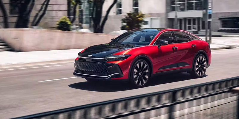 Image of a red Toyota Crown Sedan driving on a city street