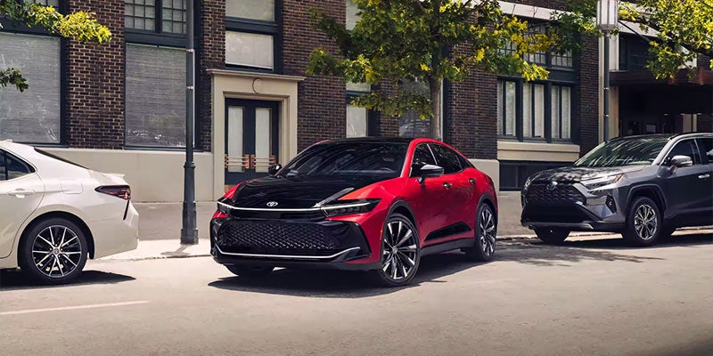 Image of a red Toyota Crown Sedan backing up to a parking place